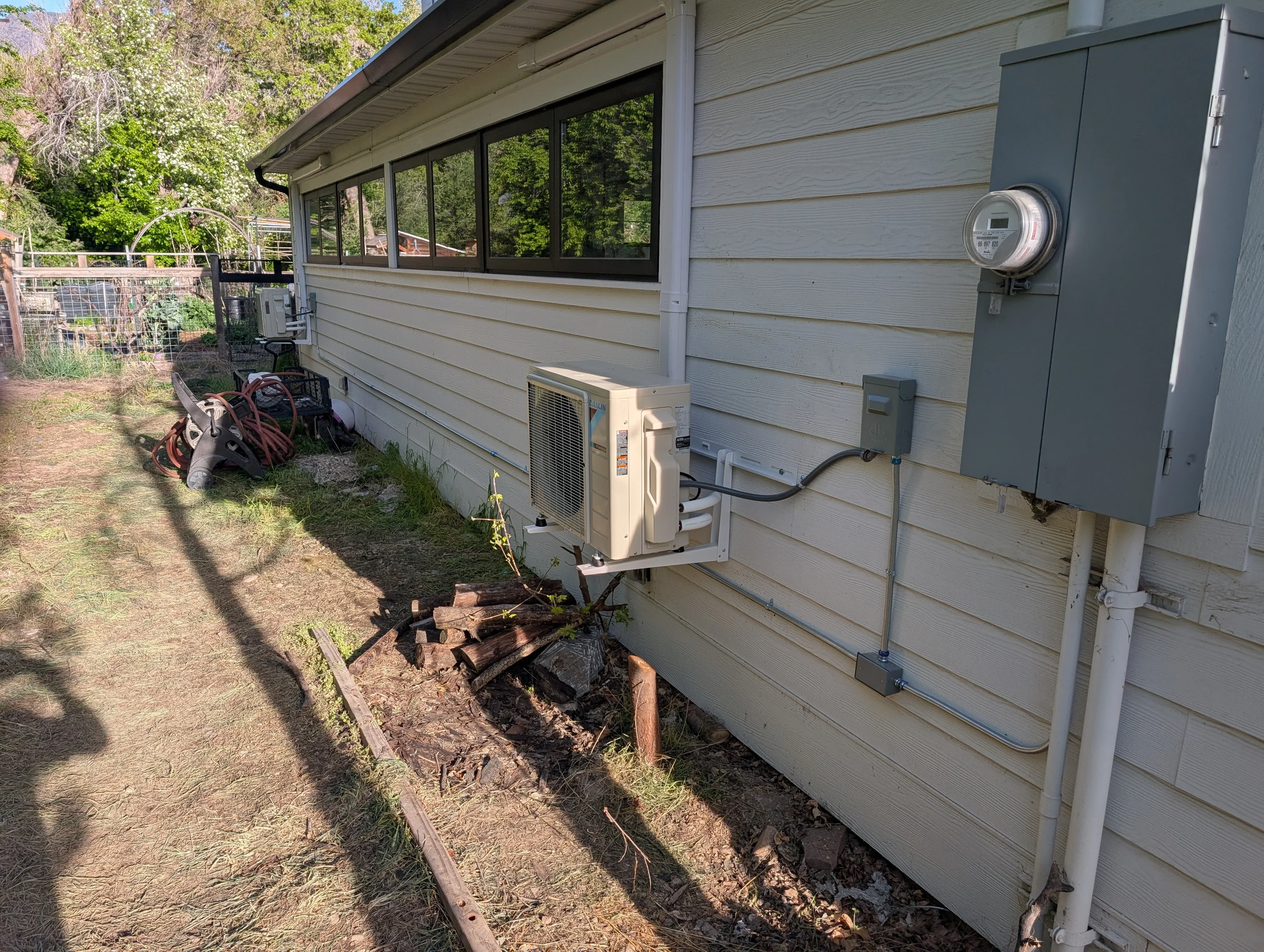 Ductless mini-split heat pump condenser unit installed on concrete pad with electrical connections and refrigerant lines
